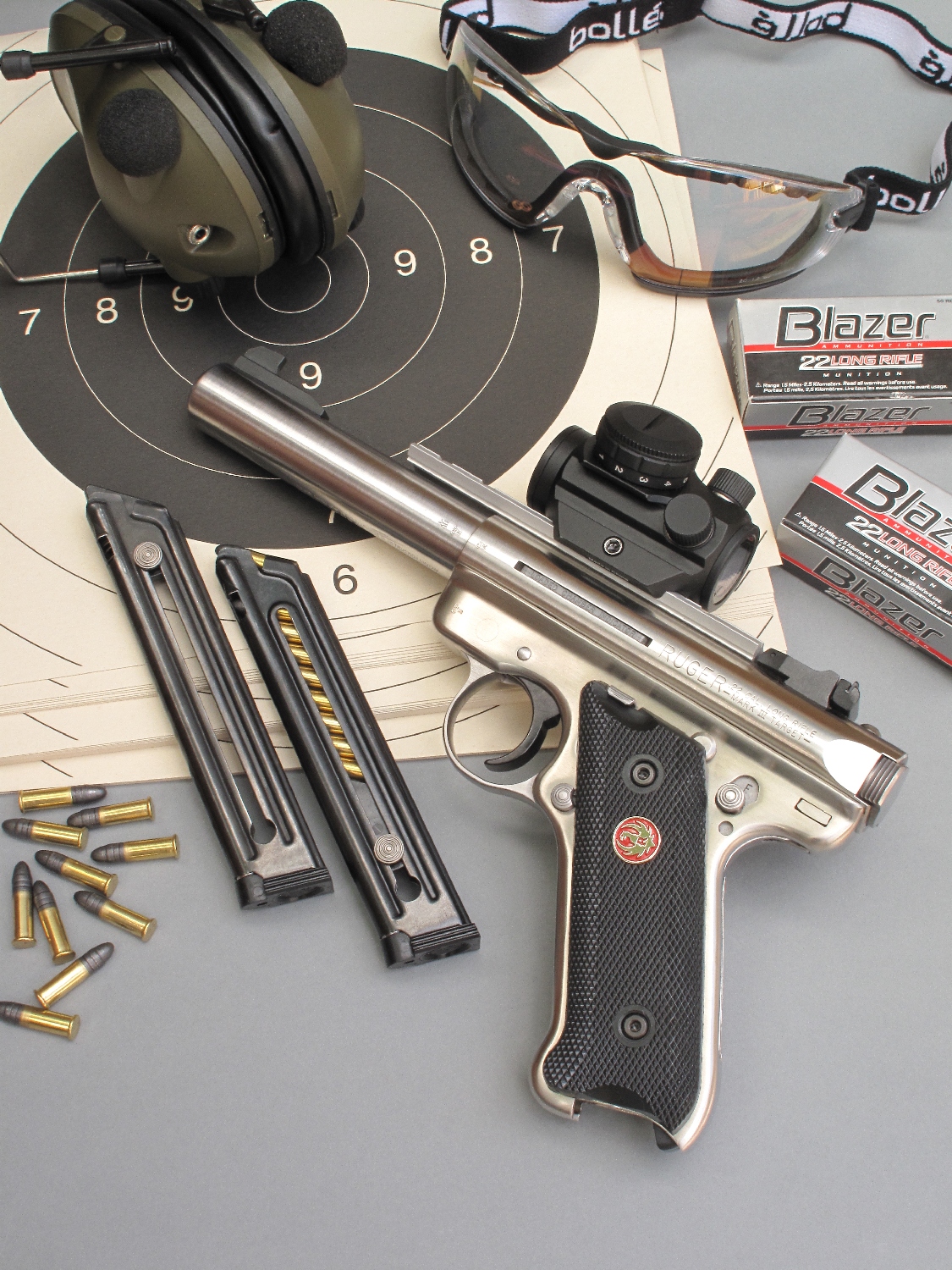 Le Ruger Mark III « Target » est ici équipé d’un viseur à point rouge compact Swiss Arms « Mini Dot Sight », installé au moyen du rail Weaver qui est livré avec le pistolet. Ses deux chargeurs de dix coups, un casque antibruit électronique Num’axes, une paire de lunettes Bollé Safety « Cobra » et des munitions CCI Blazer l’accompagnent.