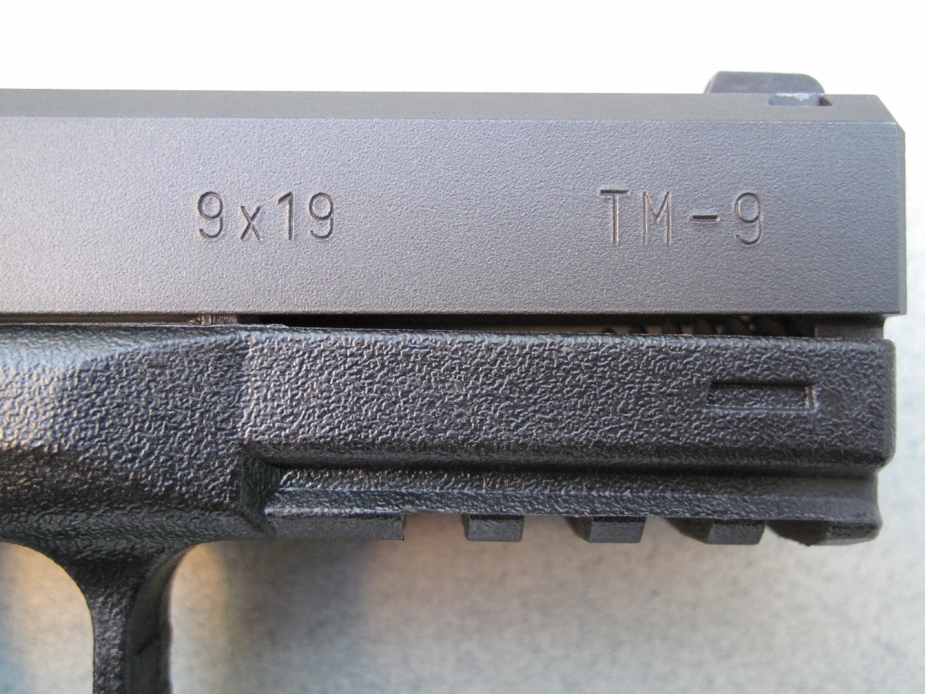 L’indication du calibre 9x19 mm et la dénomination du modèle sont frappés sur le flanc droit de la glissière.