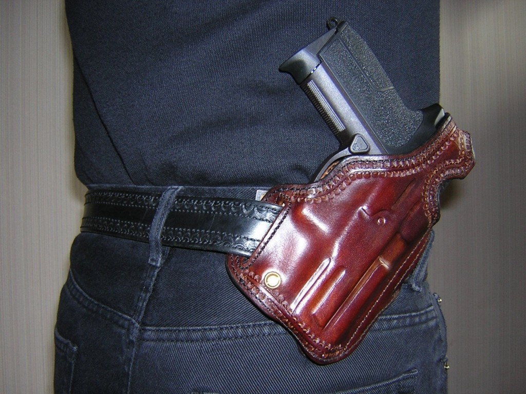 Le SIG SPC-2009 est placé ici dans un holster « Shadow » fabriqué en France par « La Sellerie du Thymerais » : cuir épais mis en forme et cousu à la main, penté « FBI », vis de rétention, bride de sûreté de type « Rear Sight Protector ».