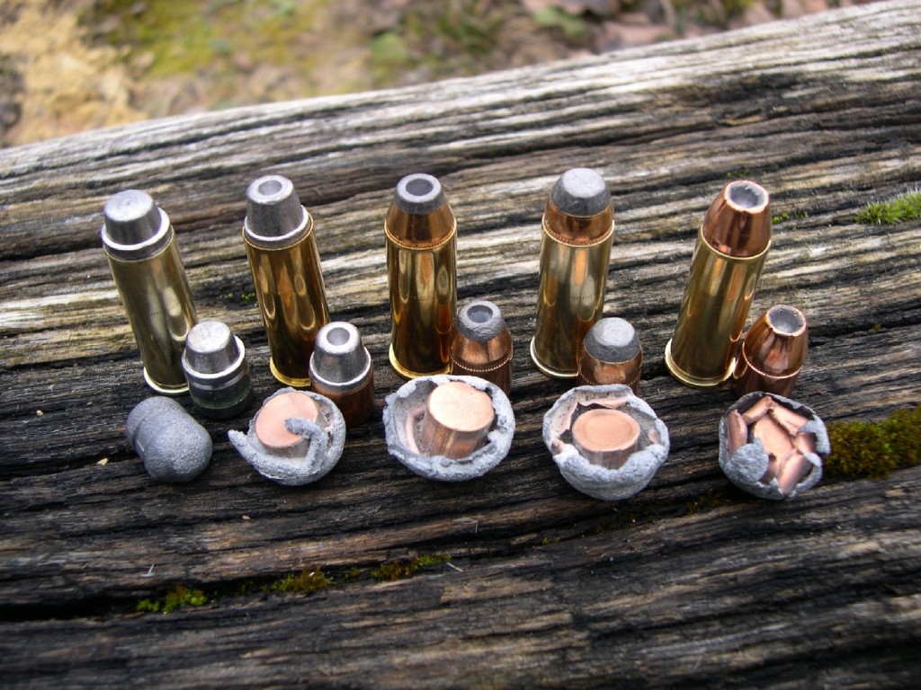 Les différentes cartouches de calibre .44 Magnum que nous avons utilisées pour ce banc d’essai, accompagnées chacune d’un projectile neuf et d’un projectile tiré à très courte distance dans un bac de sable humide (de gauche à droite) : balle plomb MPF 217 grains SWC poussée par 1,55 g de SP3 ; balle blindée Speer 225 gr SWC HP poussée par 1,65 g de SP3 ; balle blindée American Eagle 240 gr HP de la munition manufacturée ; balle blindée Speer 240 gr SP poussée par 1,60 g de SP3 ; balle blindée Hornady XTP 240 gr HP poussée par 1,20 g de SP2. On notera la remarquable expansion de ces trois derniers types de projectiles.
