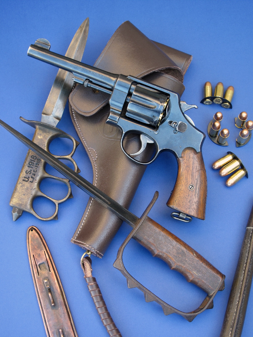 Le revolver S&W modèle 1917 que nous avons testé est accompagné ici de son holster en cuir (copie), de clips chargeurs en demi-lune (copies) garnis de cartouches modernes de calibre .45 ACP et des poignards de tranchée américains modèles 1917 et 1918 (authentiques), prêtés par la maison AAS (www.aassniper98.com).