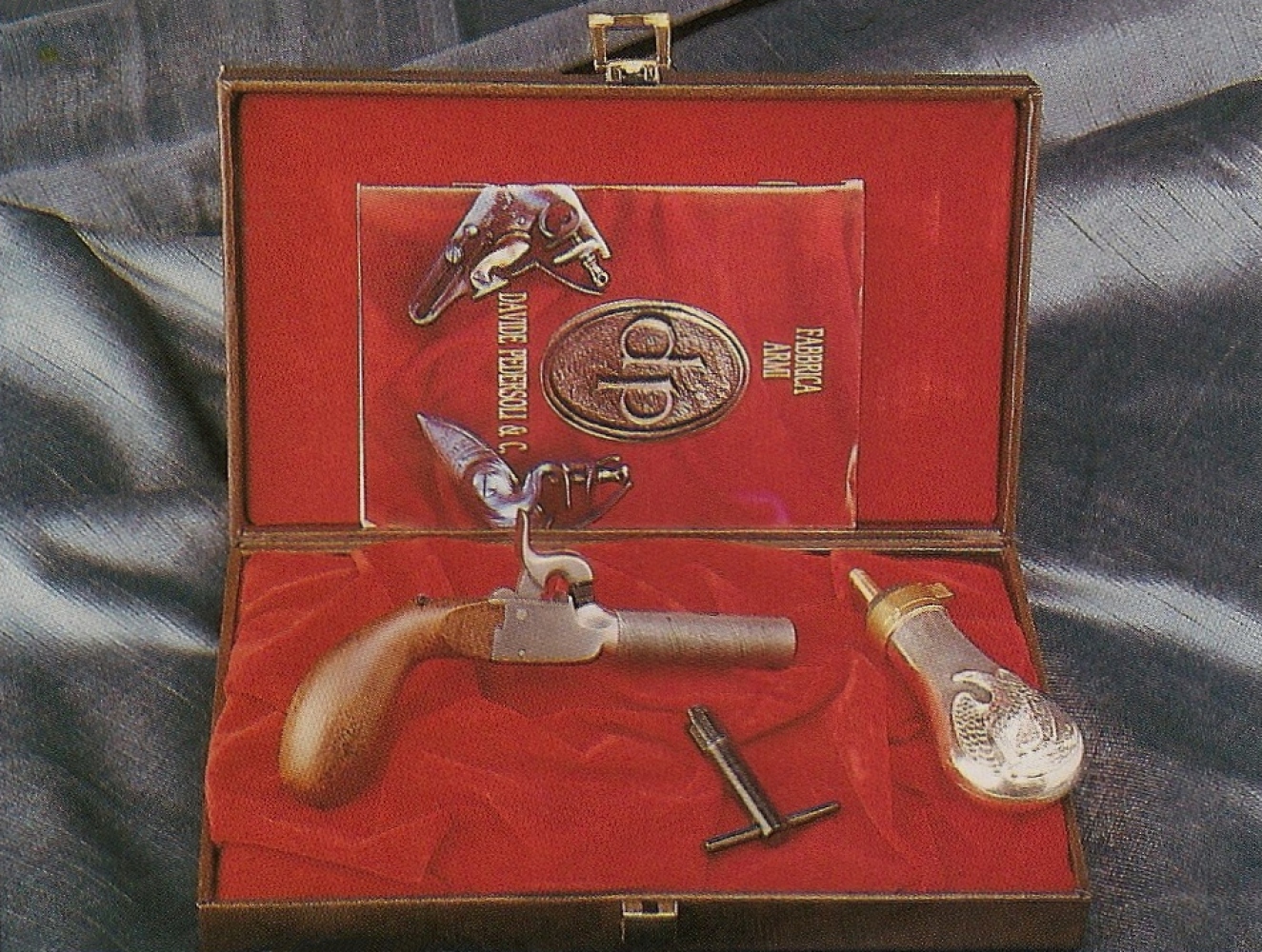 Cette réplique Pedersoli est présentée dans un coffret accompagnée d’une petite poire à poudre et d’une clé spéciale à double usage, permettant à la fois de dévisser le canon pour le chargement et la cheminée pour le nettoyage.