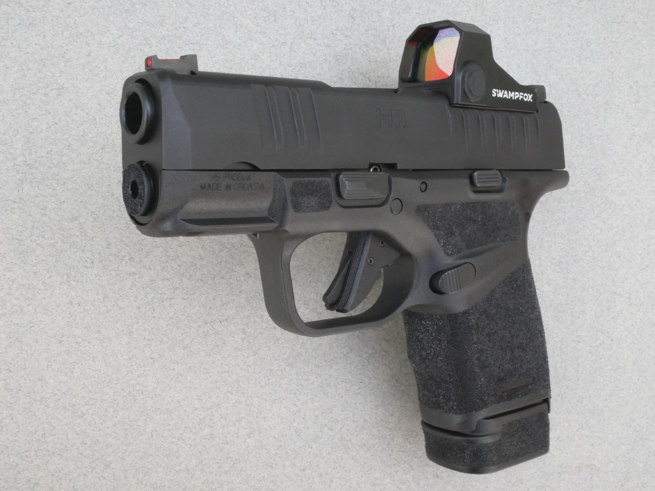 Le pistolet HS H11 RDR muni de son chargeur de treize coups et du micro-viseur reflex modèle « Sentinel 1x16 » de la firme américaine Swampfox.